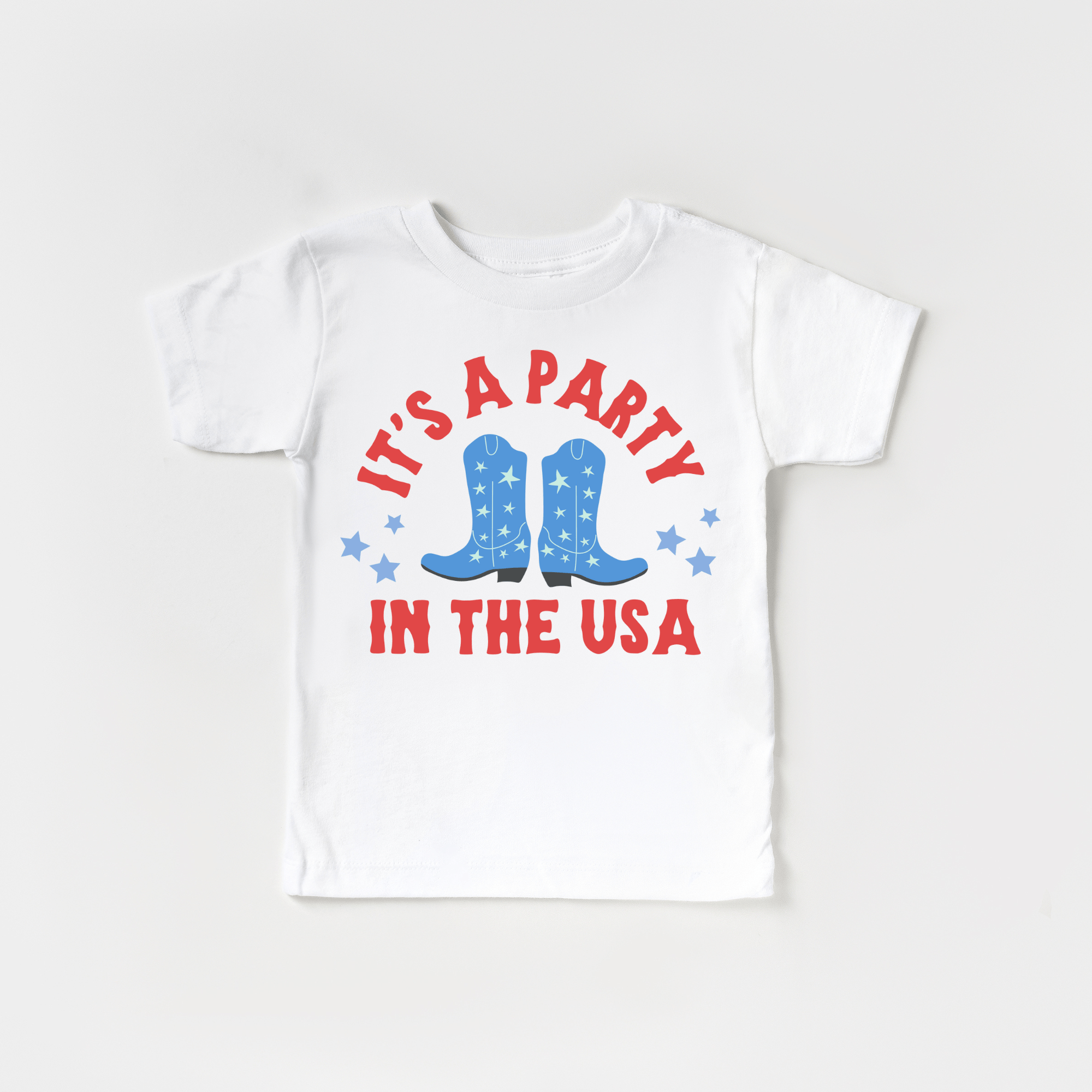 White toddler t-shirt with 'It's a party in the USA' and cowboy boots graphic, patriotic apparel.