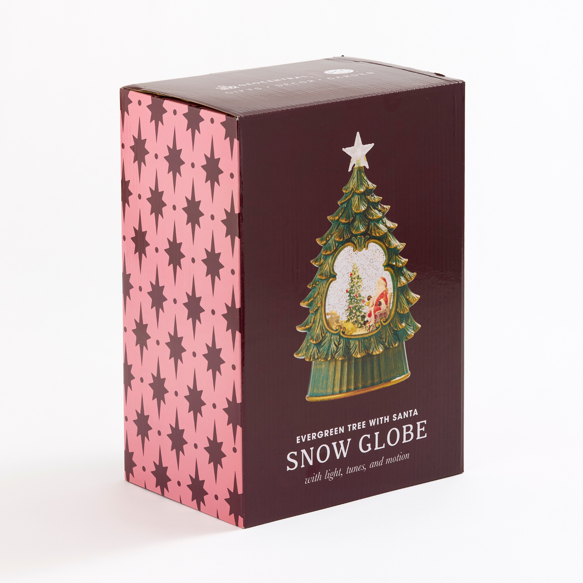 A boxed holiday ornament or decorative tree globe product shown upright on a white studio background. The box is dark burgundy on the front with a printed green Christmas tree and snow globe illustration, and the side panel is pink with repeating dark star motifs.