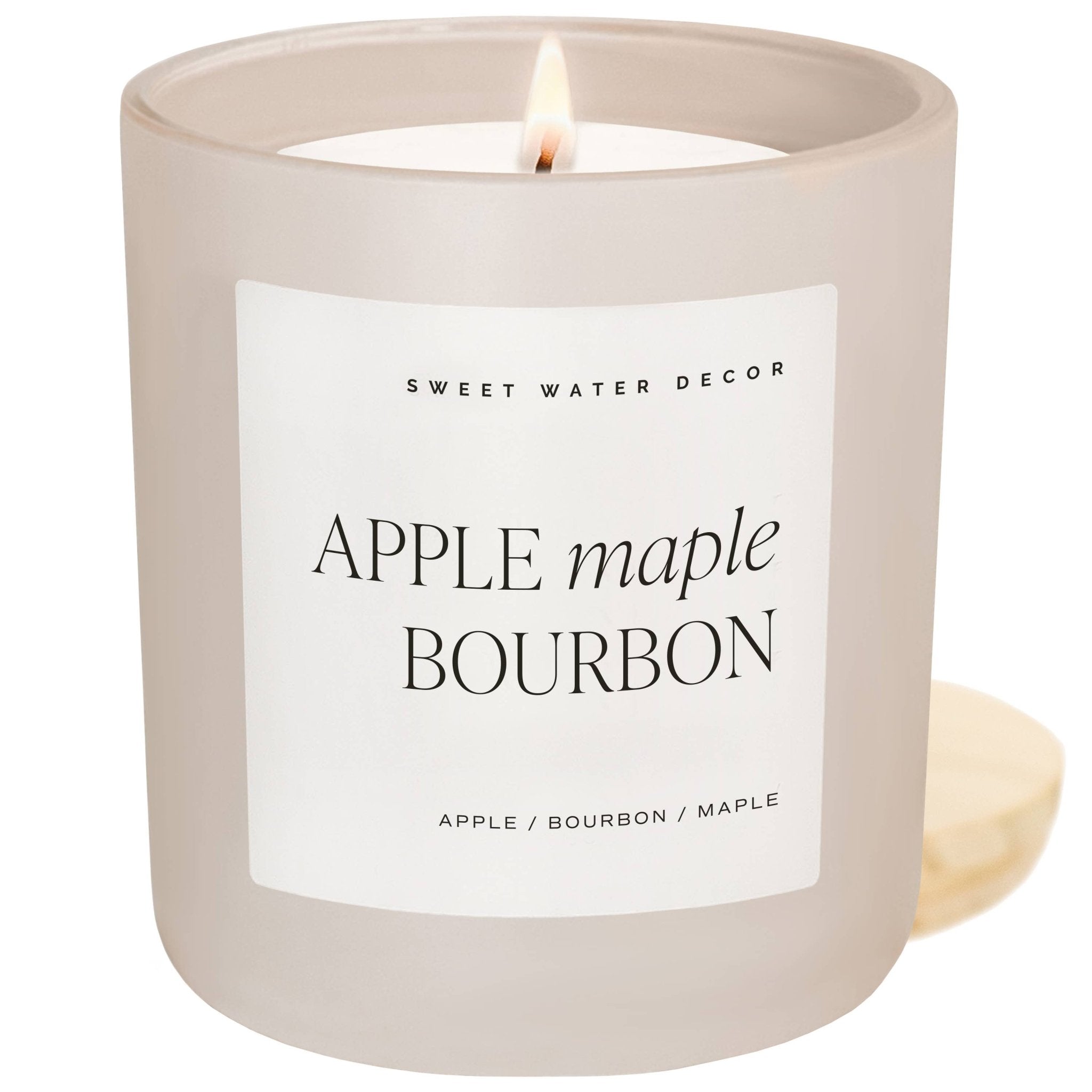 Candle with 'Apple Maple Bourbon' label on a white background