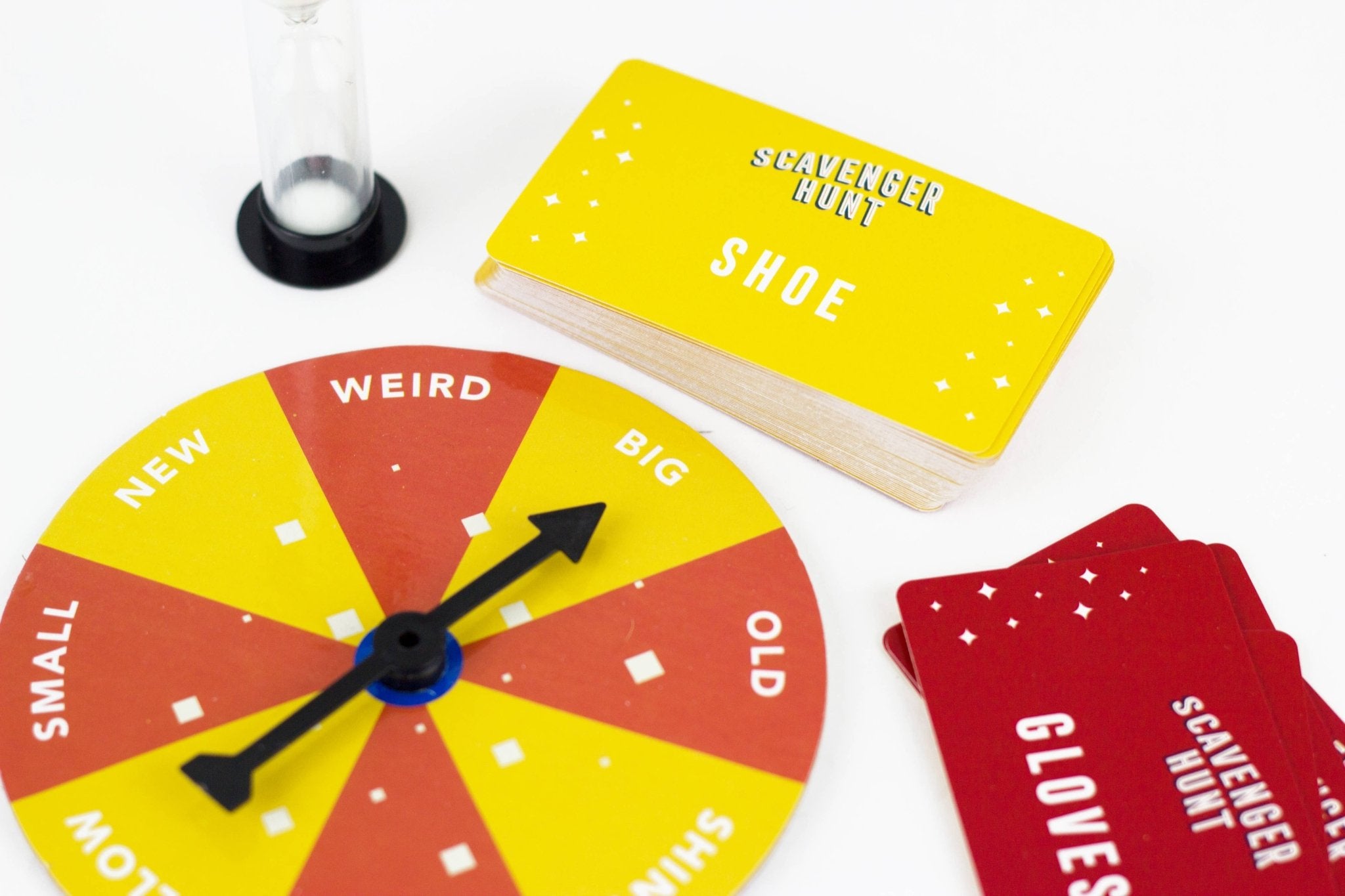 Scavenger hunt game components including a wheel, cards, and a notebook on a white background