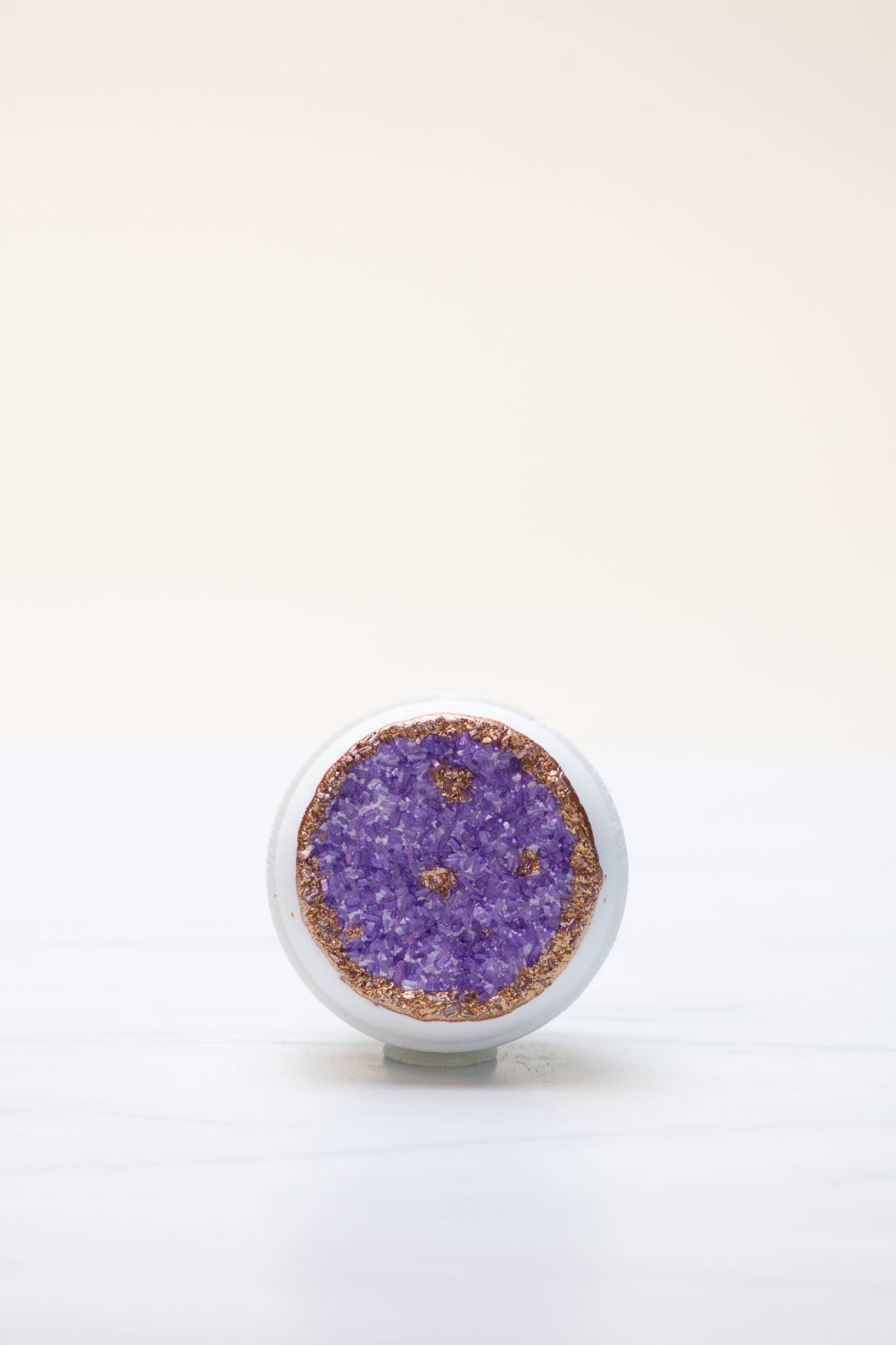 Amethyst geode bath bomb with gold glitter detail.