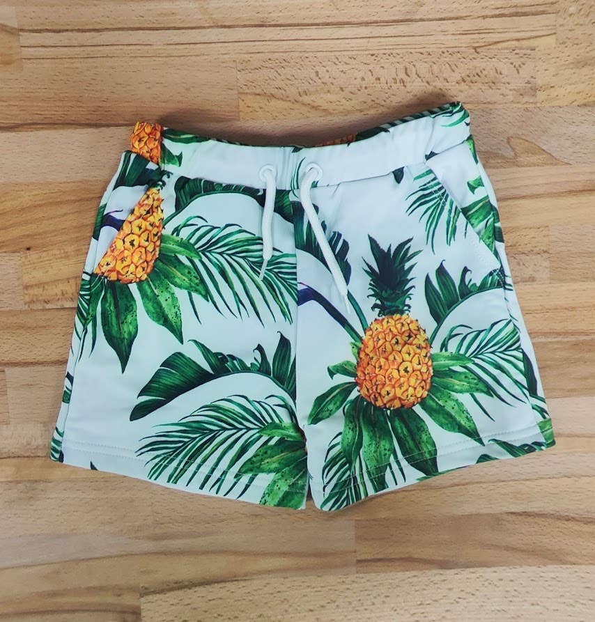 Tropical pineapple print swim trunks for boys, featuring a drawstring waist and side pockets.
