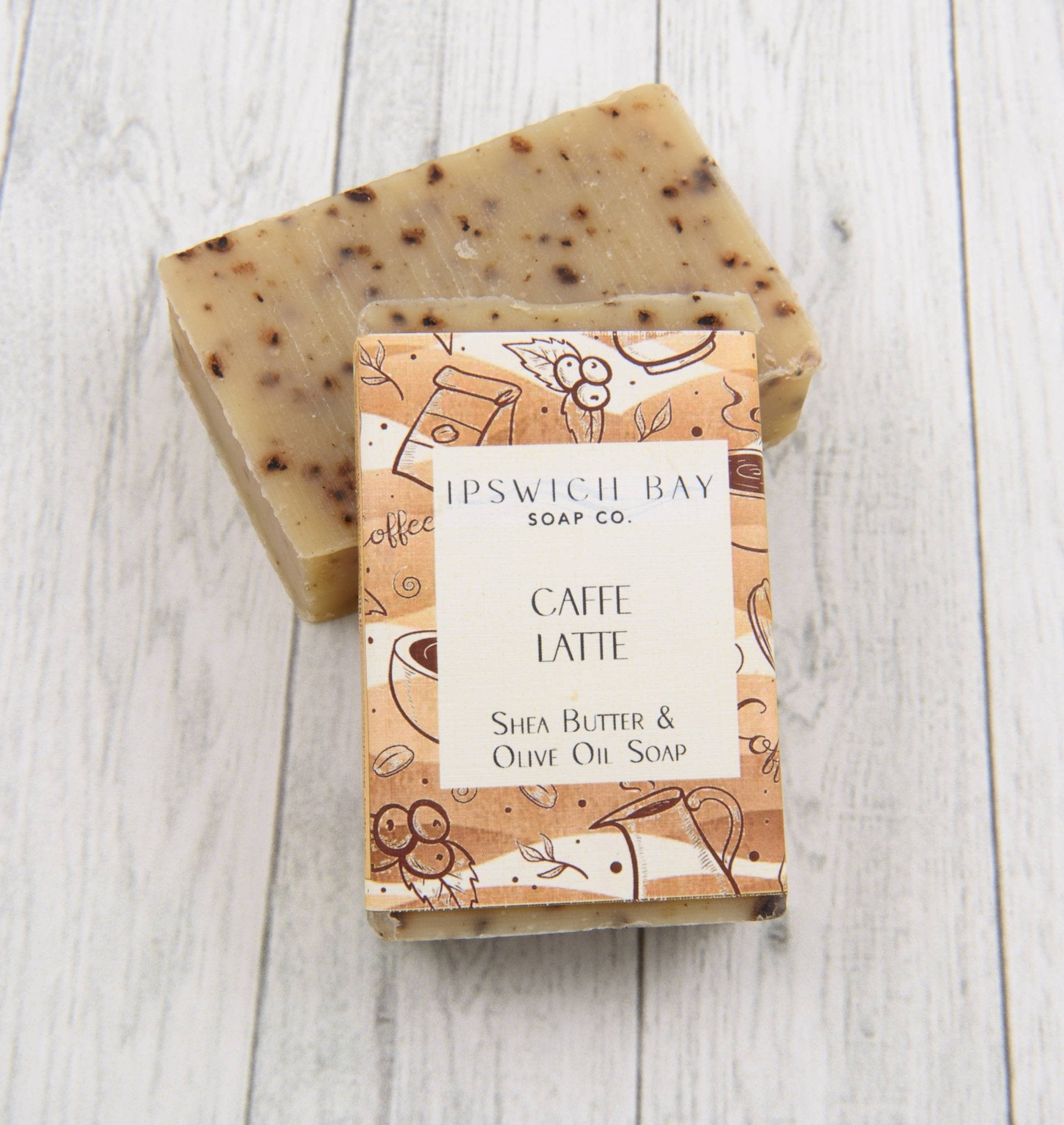 Shea butter and olive oil soap bar with packaging on a wooden surface