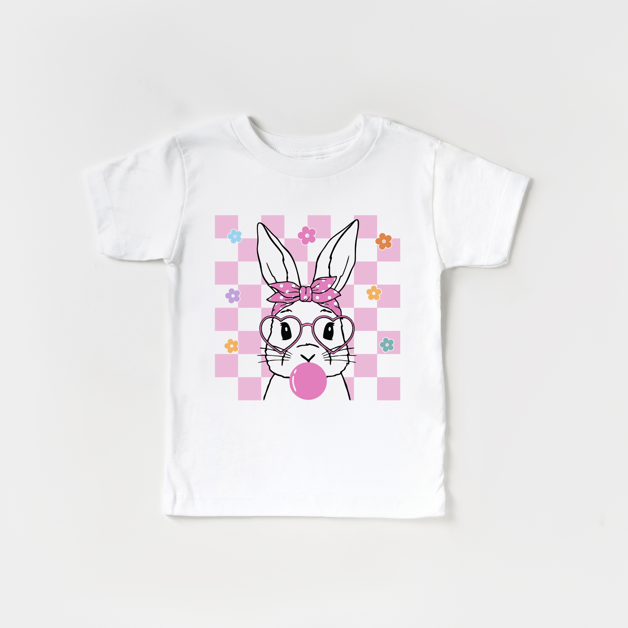 White t-shirt with Easter bunny graphic wearing glasses and blowing bubblegum on pink checkered background.