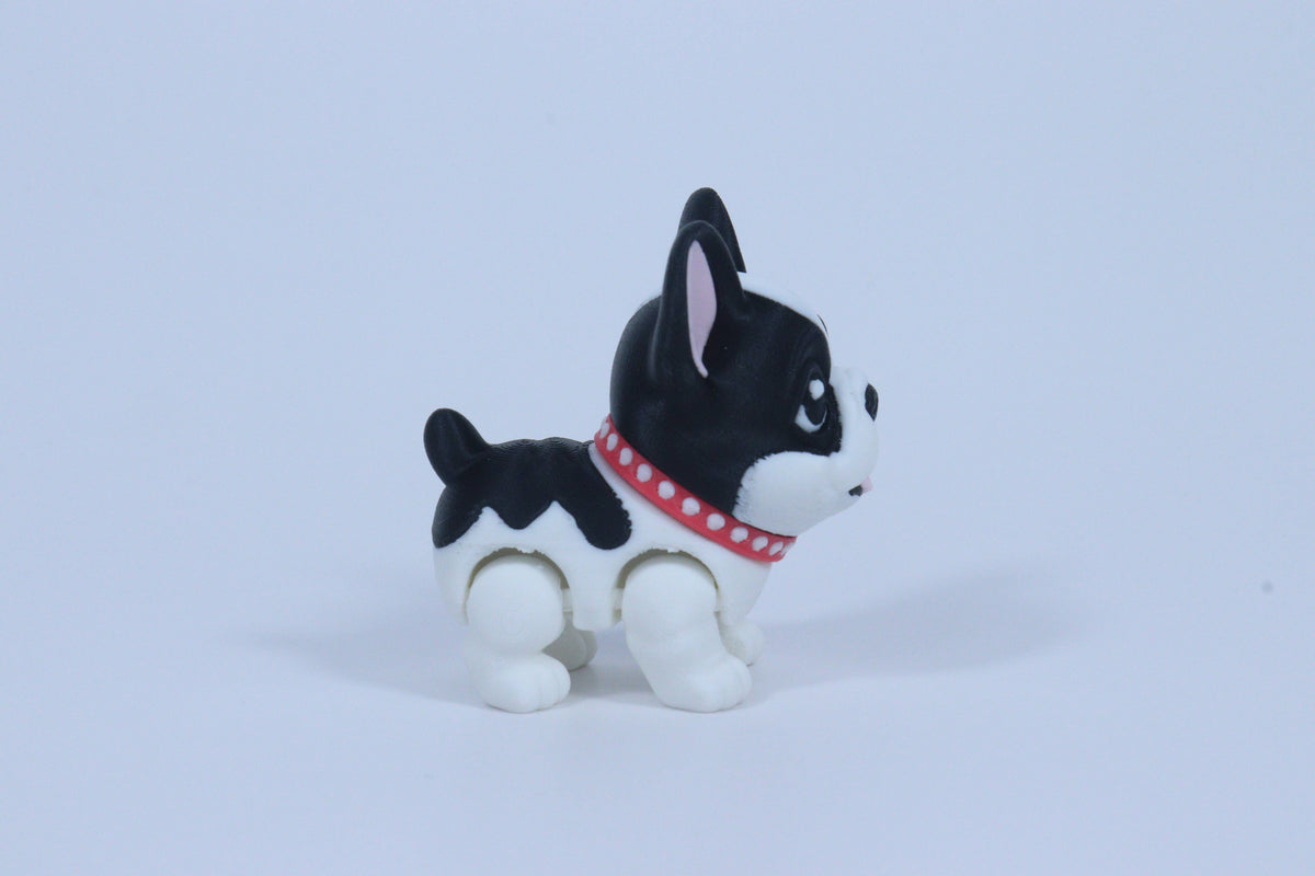 Black and white dog figurine with a red collar on a light blue background