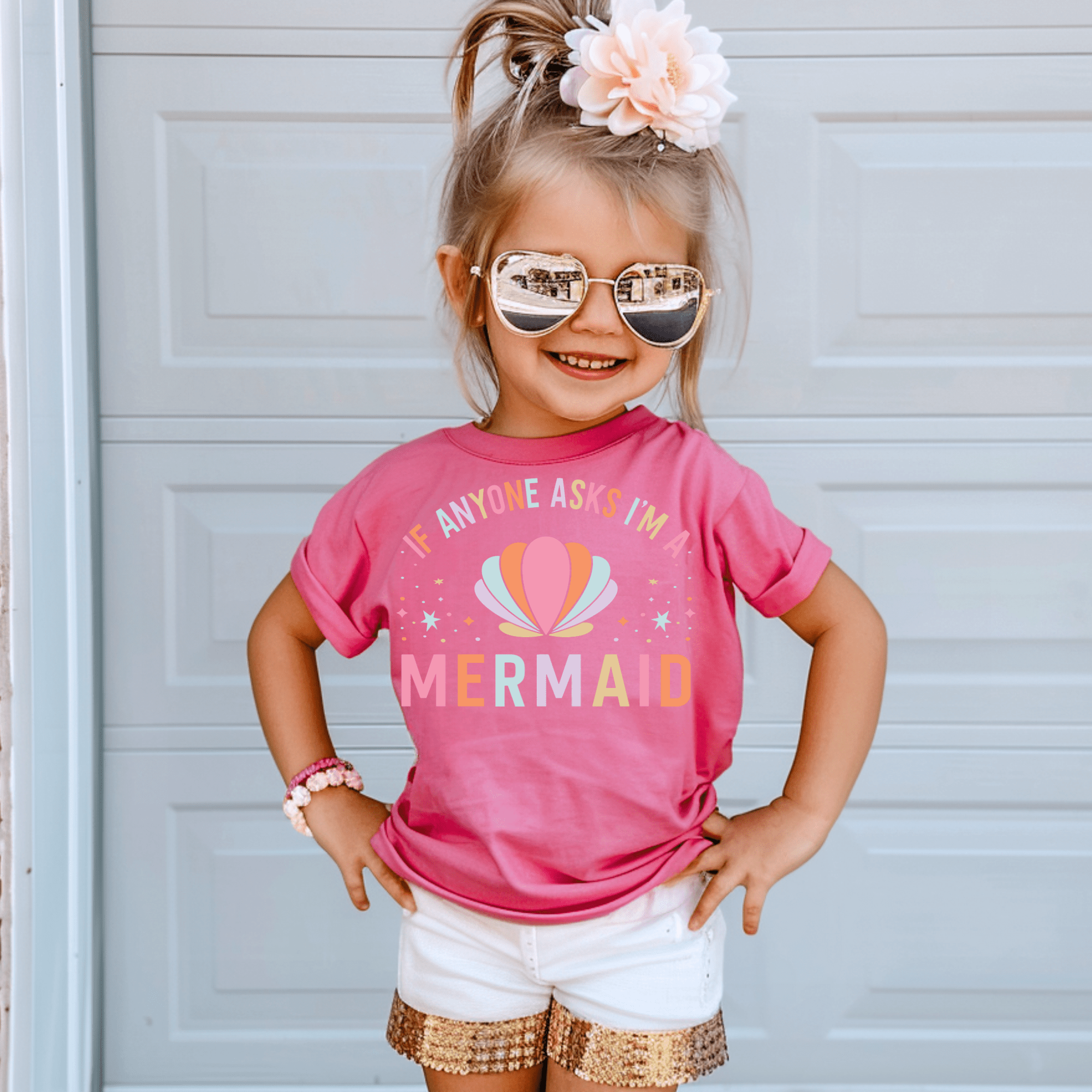 Girl in pink 'If anyone asks, I'm a mermaid' t-shirt and gold sequin shorts.