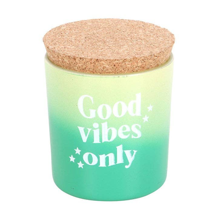 Good Vibes Only candle in an ombre green glass jar with a cork lid.