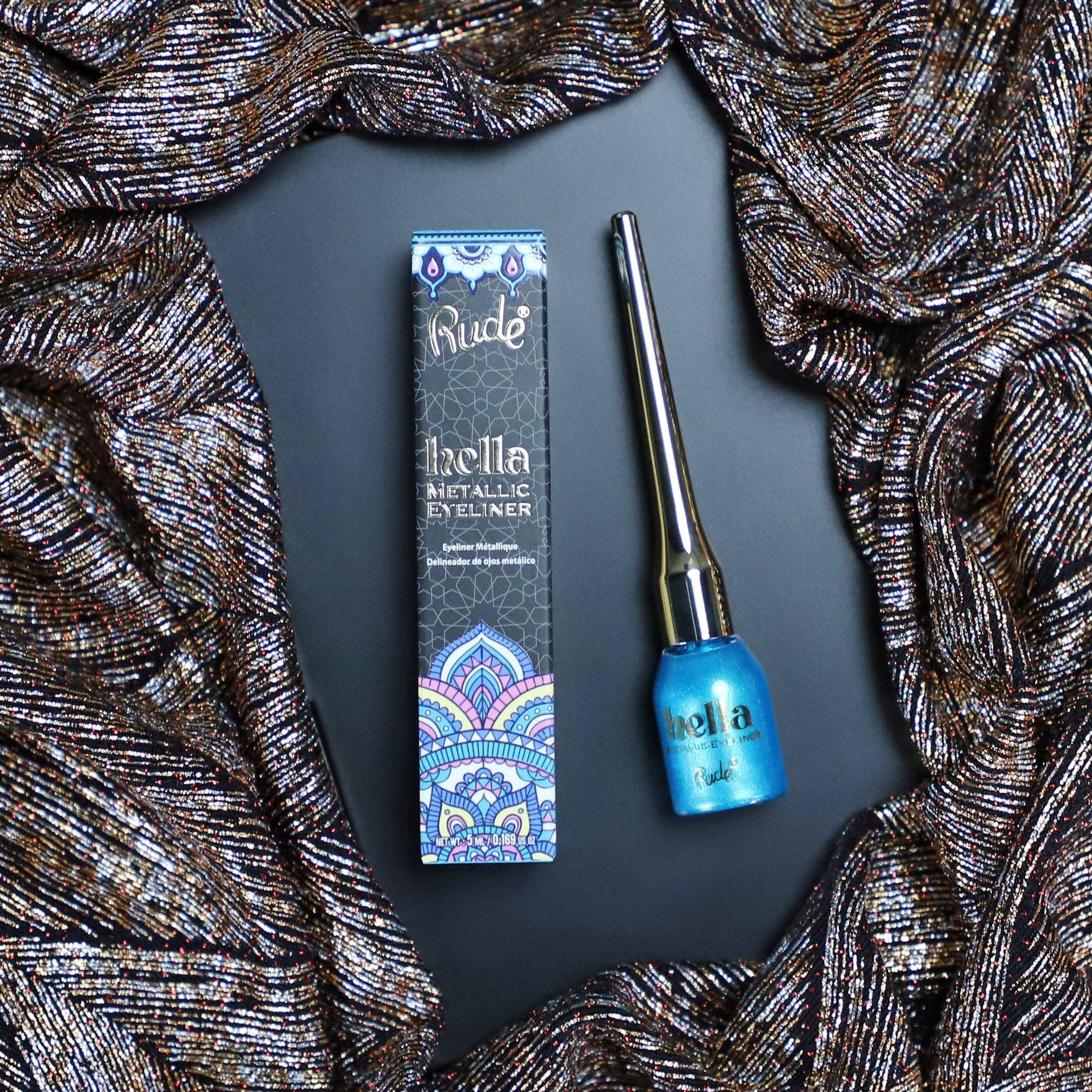 Rude Cosmetics eyeliner with packaging on a dark background with decorative fabric