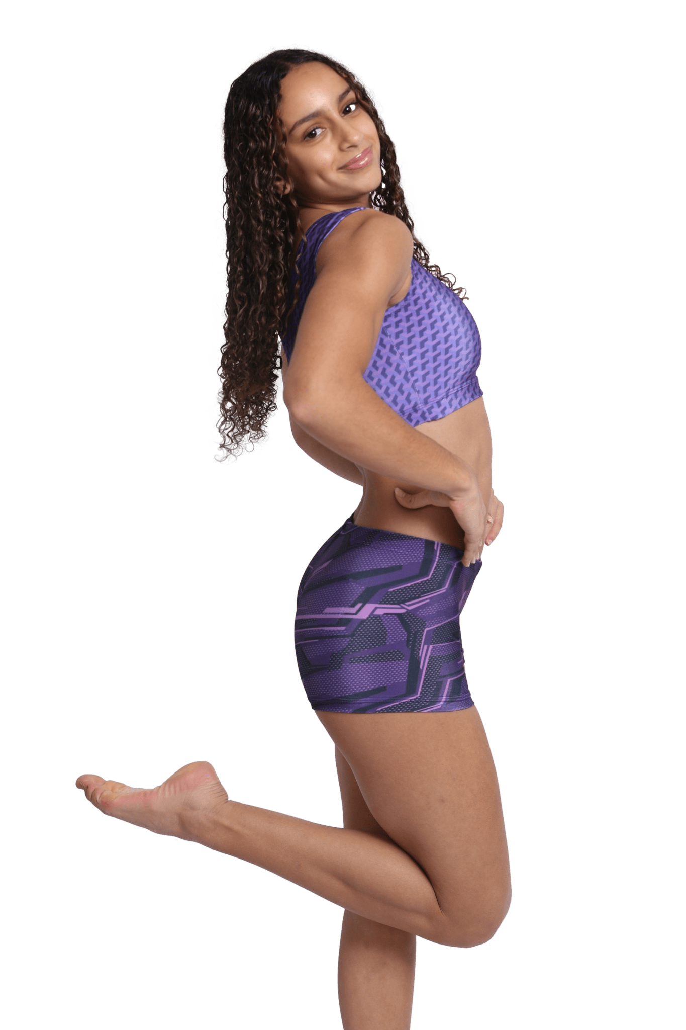 Woman in purple patterned sports bra and shorts workout outfit.