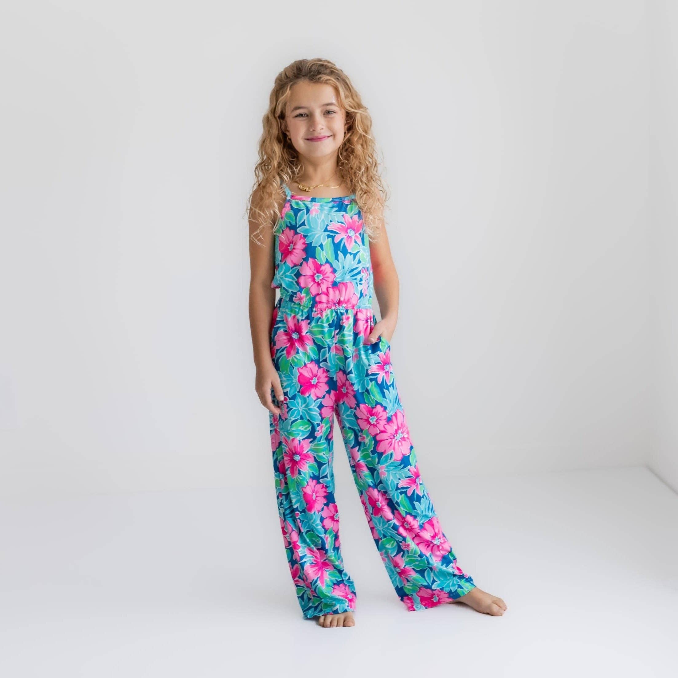 Girl's floral print jumpsuit in pink, blue, and green.