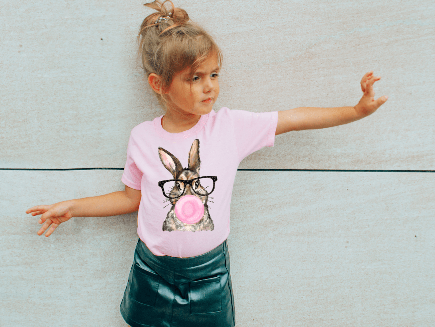Girl's pink t-shirt with bunny graphic wearing glasses and blowing bubblegum.