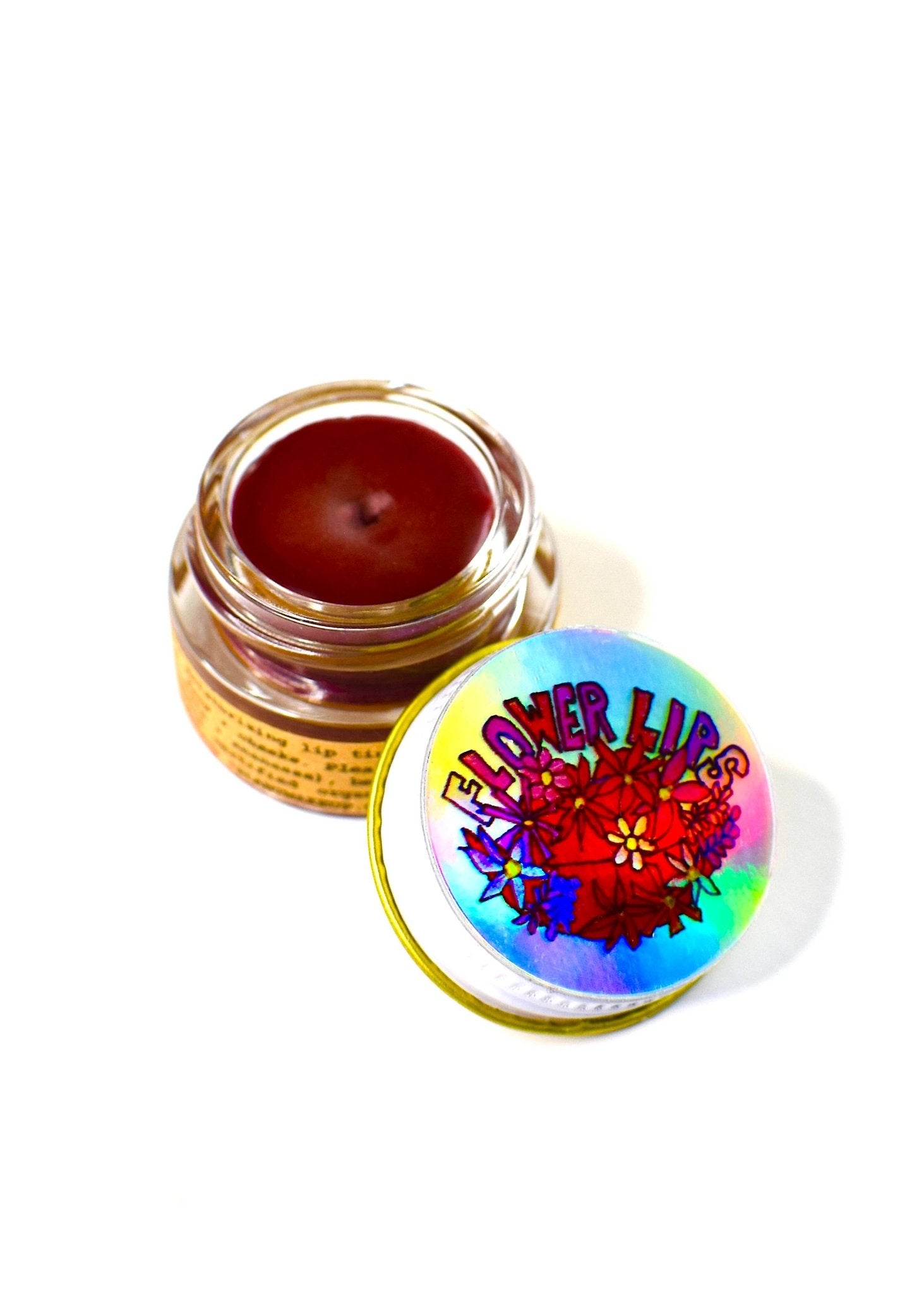 Flower Lips plant-based lip tint in glass jar with floral lid.