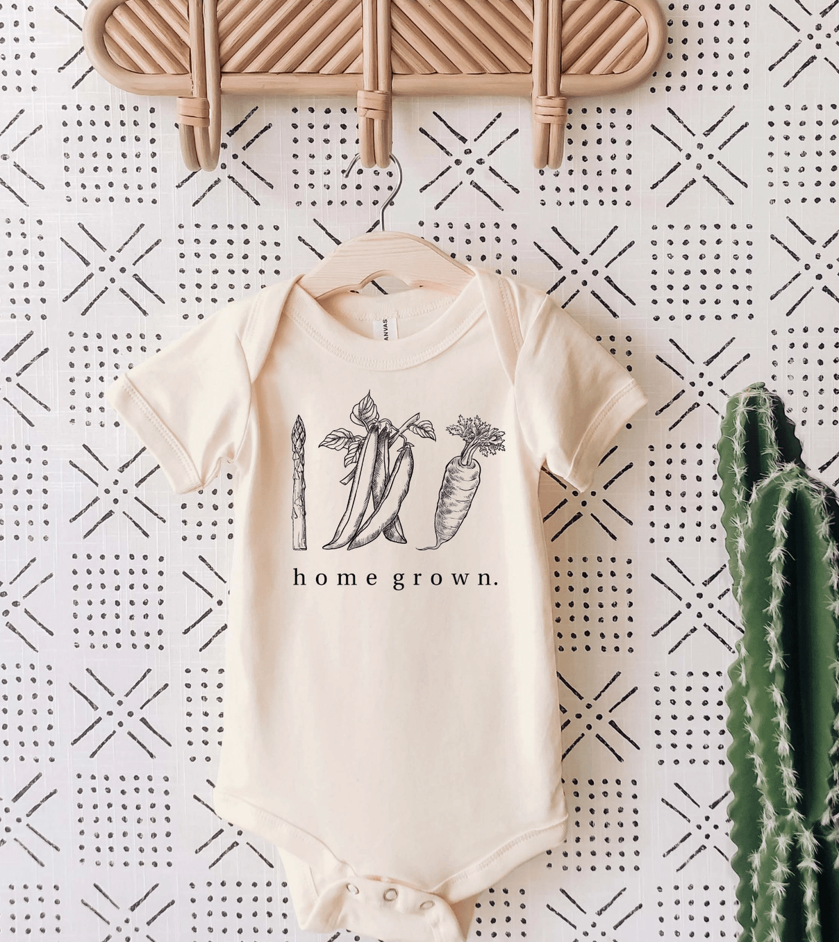 Beige baby bodysuit with 'home grown' vegetable graphic. Cute infant clothes.