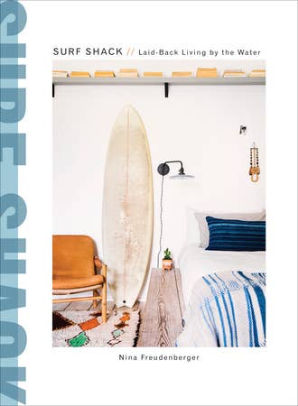 Surf Shack: Laid-Back Living by the Water book cover. Interior design with surfboard, chair, and bed.