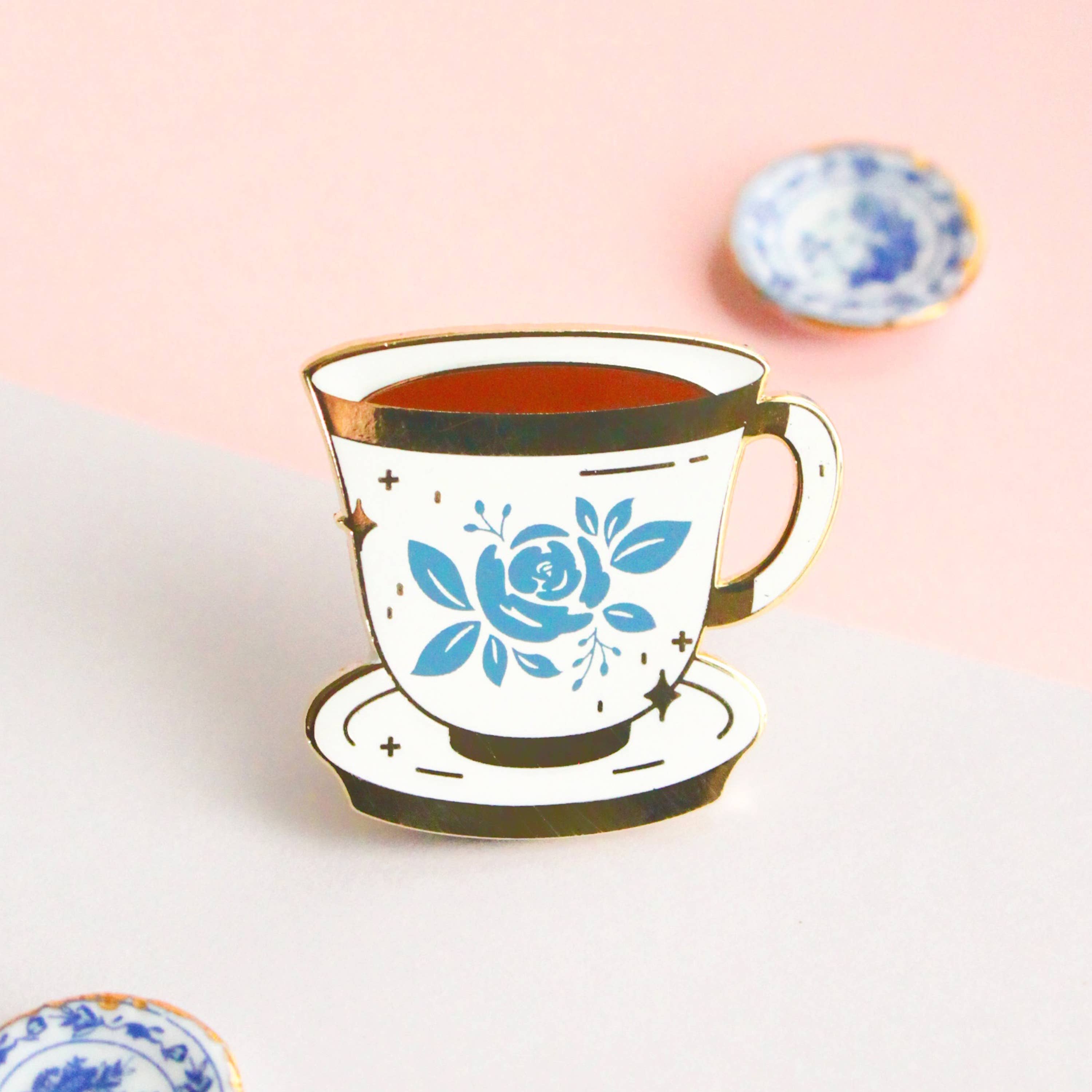 blue and white floral teacup enamel pin with a saucer design
