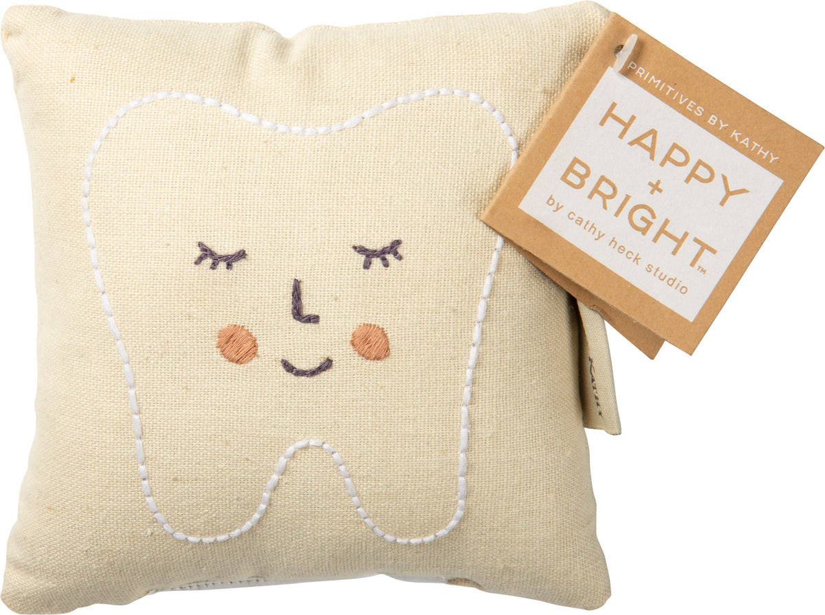 Decorative pillow shaped like a tooth with a face design, featuring a 'Happy + Bright' tag.