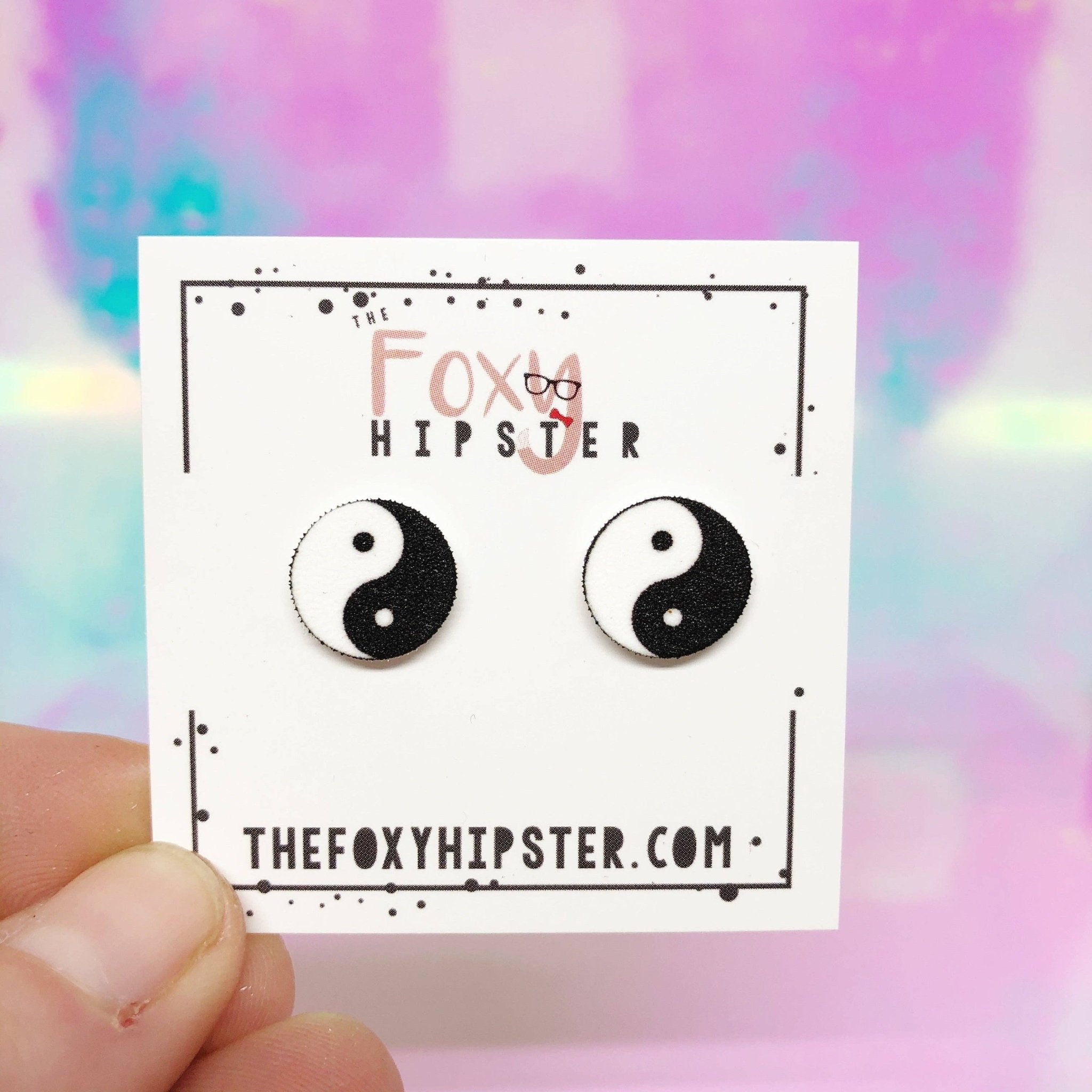 Yin Yang earrings on a display card from The Foxy Hipster, featuring a black and white Taoist symbol.
