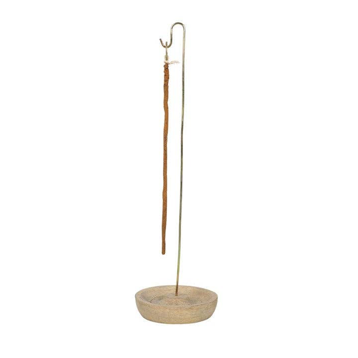 Incense holder with wooden base and metal stand, holding a lit incense stick.