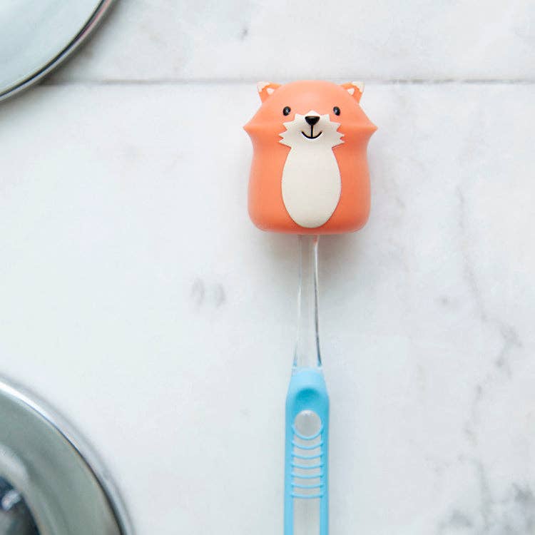 Fox toothbrush holder with blue toothbrush, bathroom accessory.