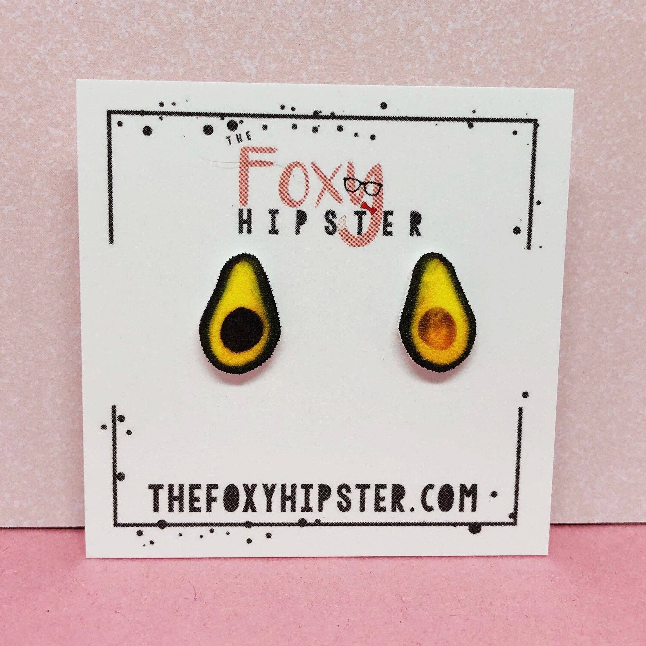 The Foxy Hipster avocado stud earrings on a white display card.