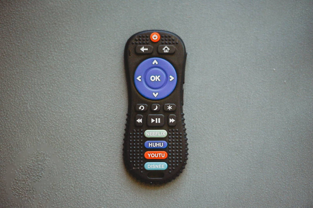 Black remote control with blue OK button on a gray background