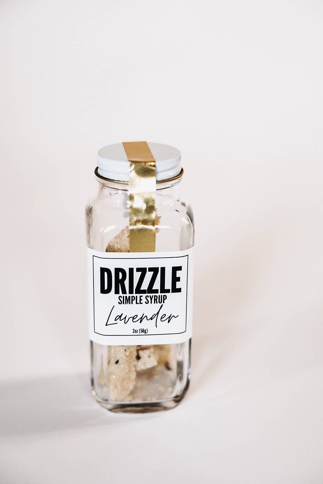 Drizzle Lavender Simple Syrup in a 2oz clear glass jar with sugar crystals and a white label