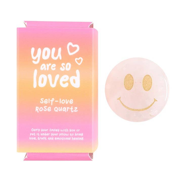 Self-love Rose Quartz with smiley face and box that says 'You are so loved'.