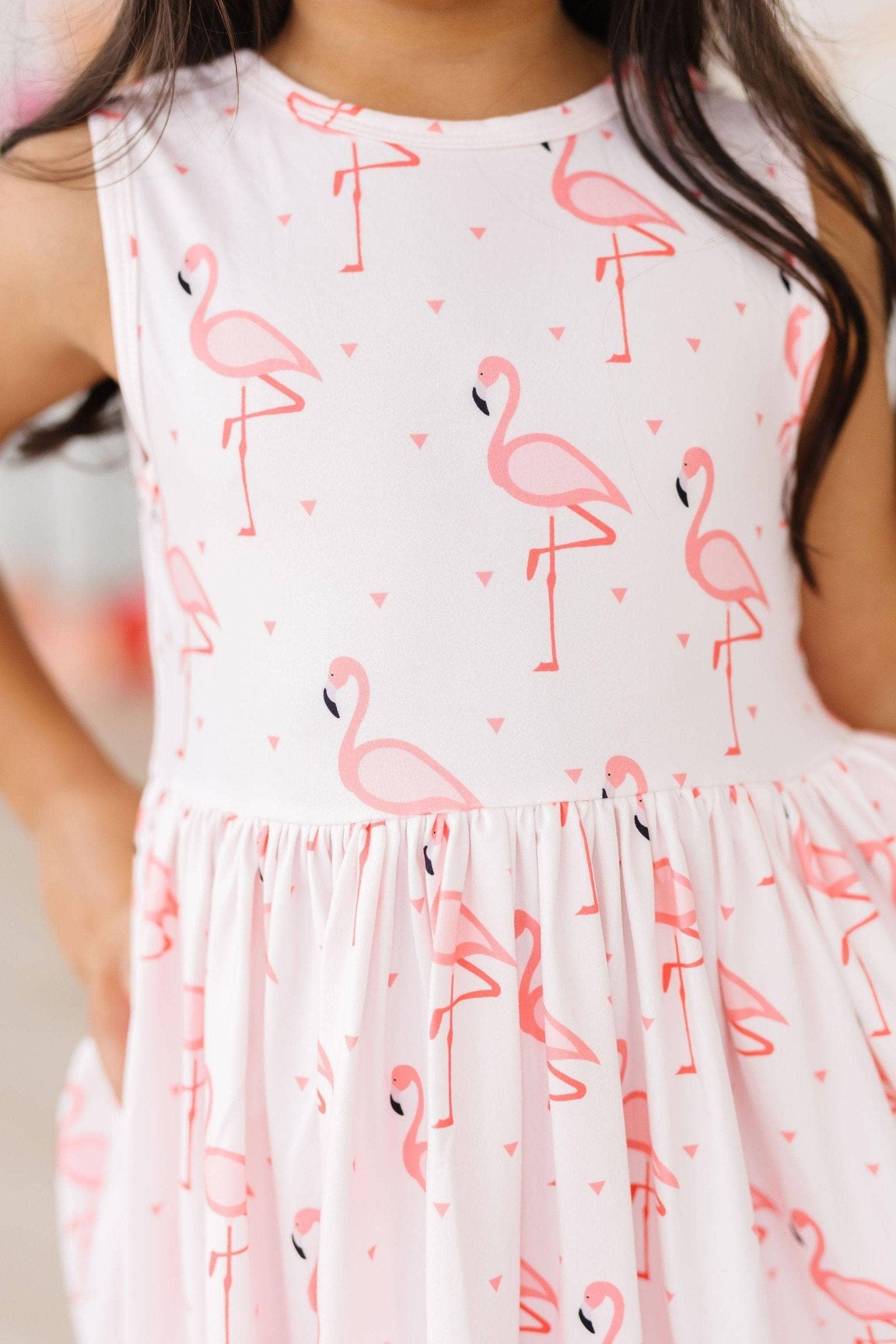 Girl's sleeveless dress with pink flamingo print and gathered skirt.