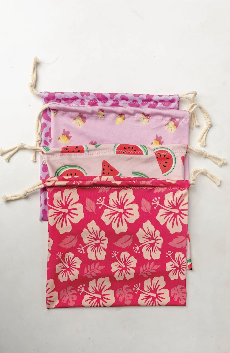 Set of three drawstring bags with floral and fruit patterns on a white background