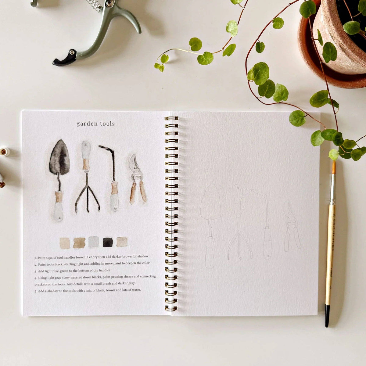 Open book on garden tools with gardening tools and plants on a white surface
