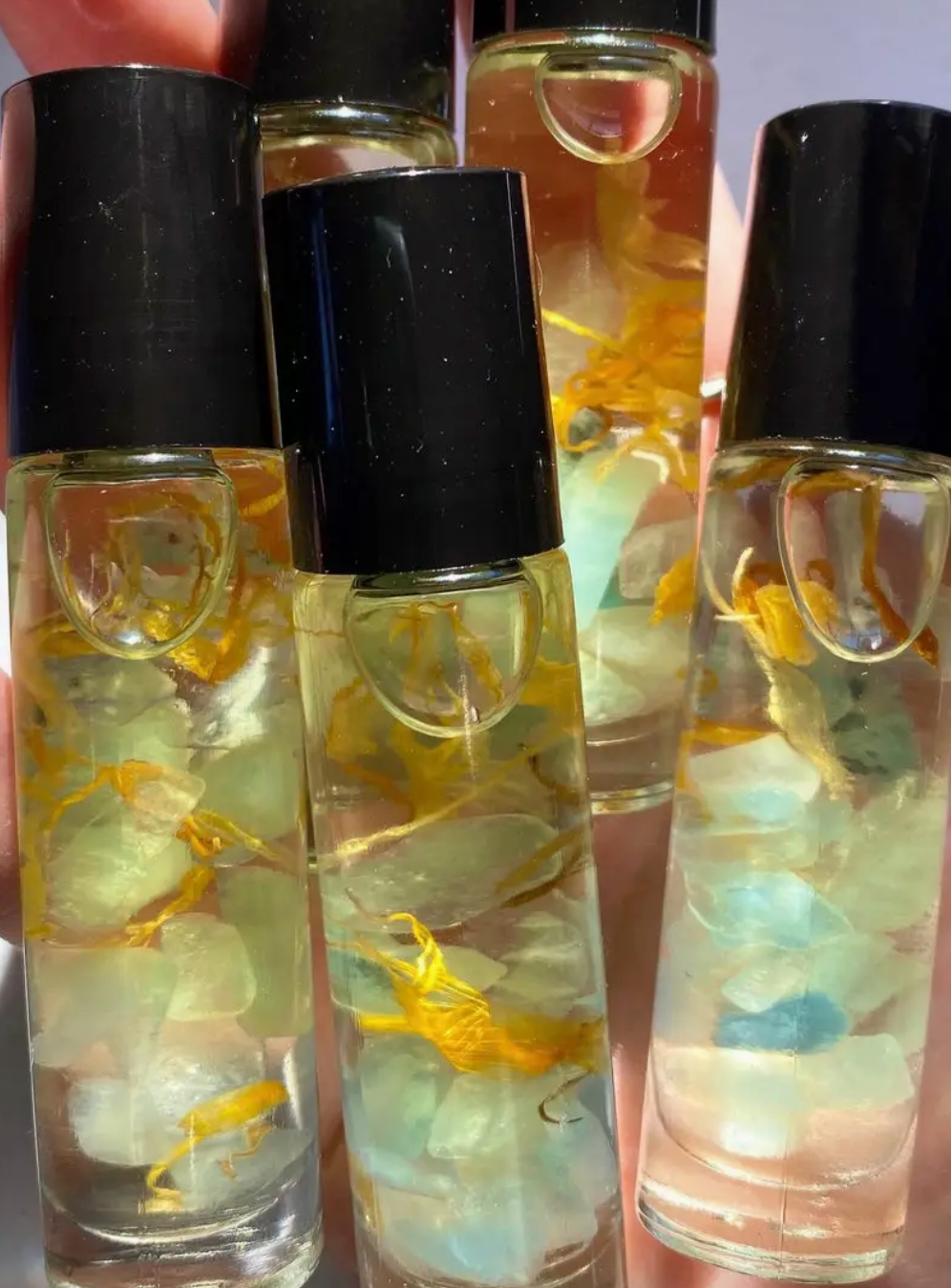 clear glass bottle with essential oils and crystals in a roller bottle