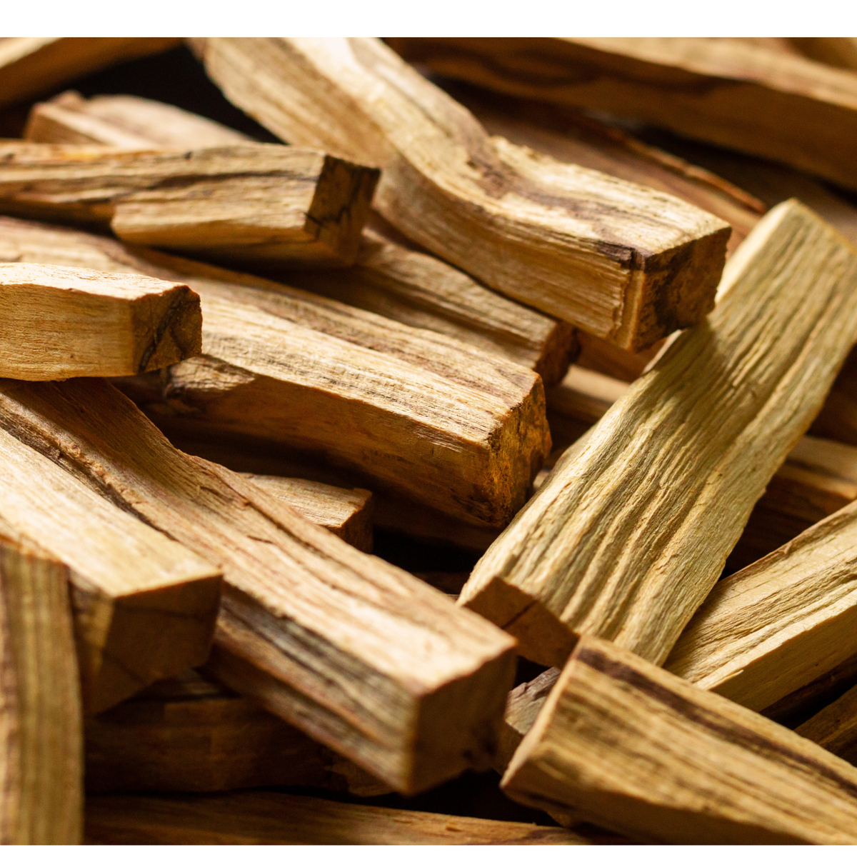 A close-up pile of natural wood chips or bark pieces with visible grain and rough, textured surfaces.