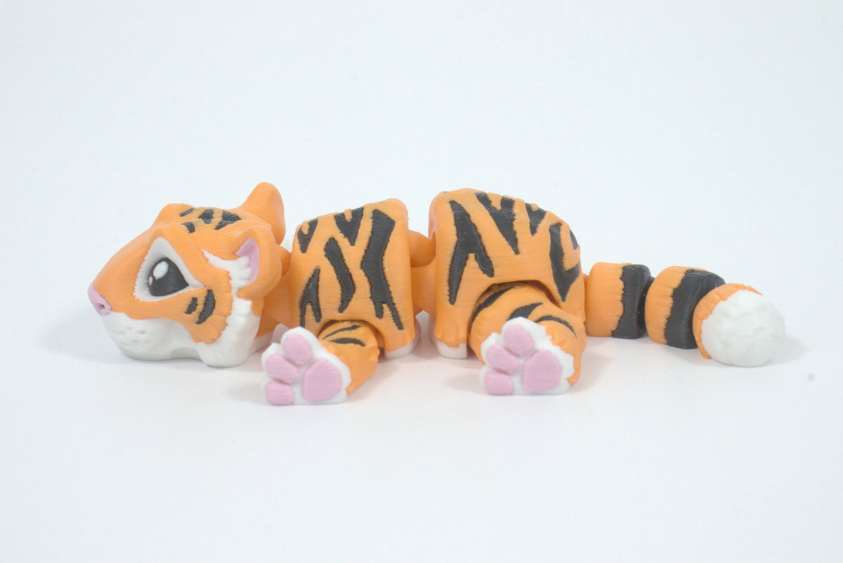 3D-printer toy tiger with orange, black, and white stripes on a white background