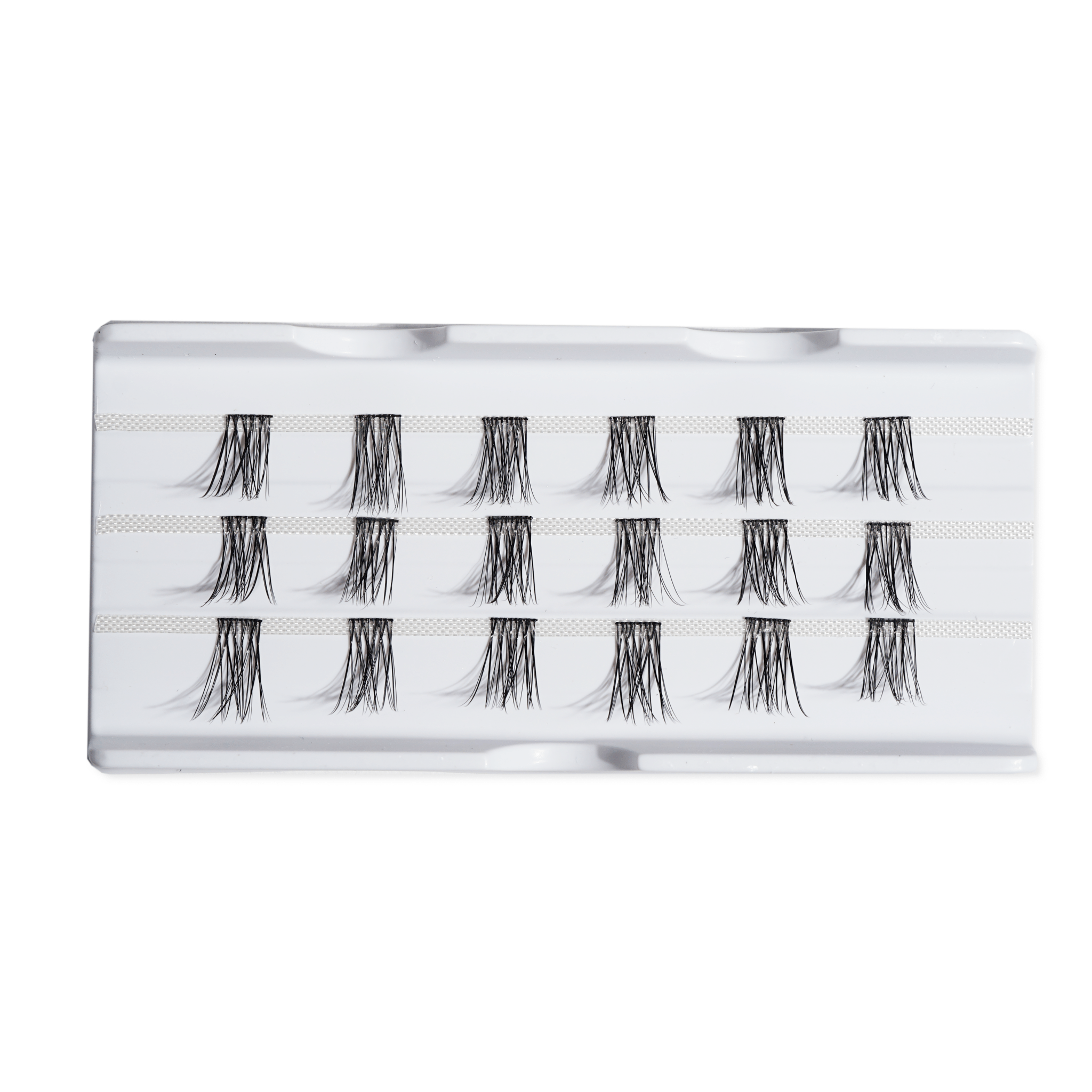 Individual false eyelashes in a white tray, ready for application.