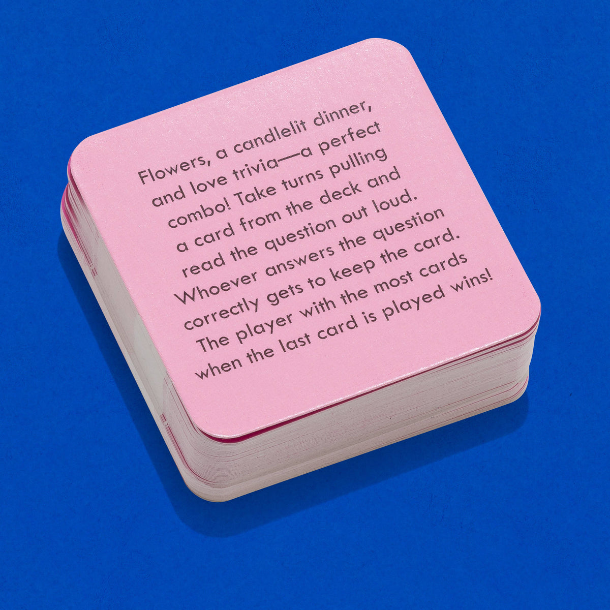 Pink card game box with text on a blue background