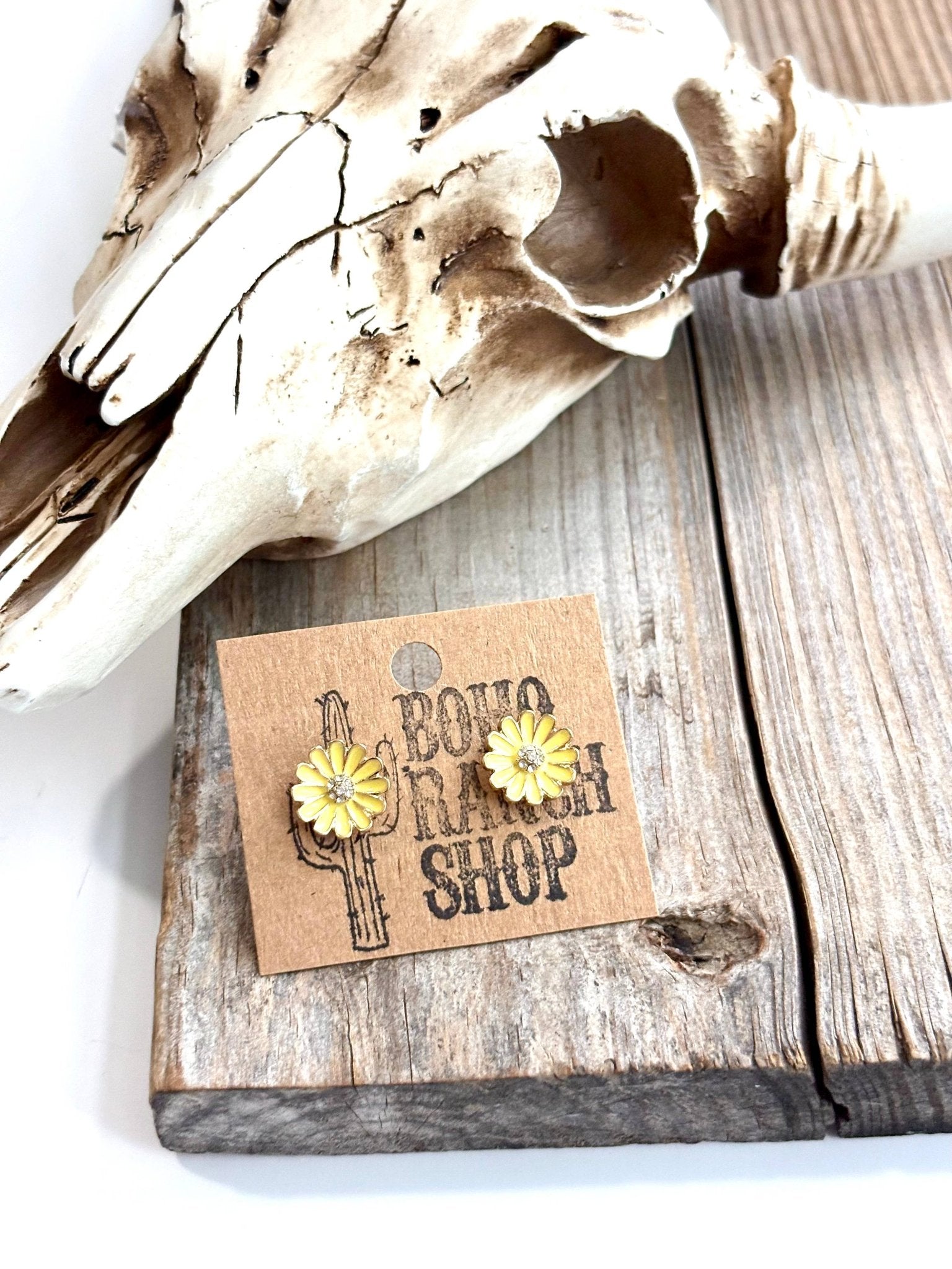 Earring card with 'A Boho Ranch Shop' branding on a wooden surface with a cow skull.