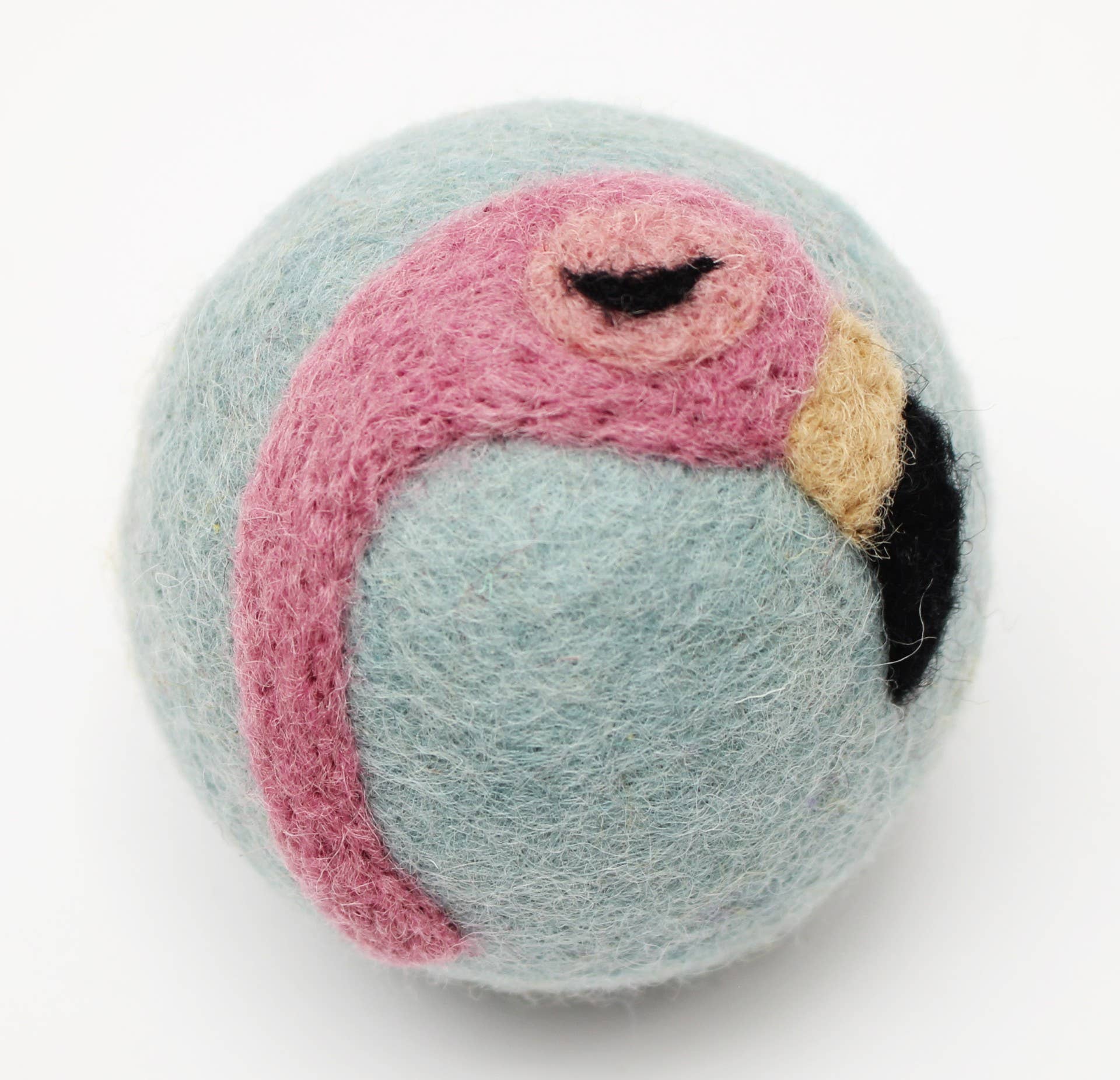 Fluffy pink flamingo wool dryer ball on a light blue ball against a white background