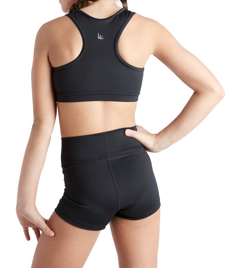 Person wearing a black sports bra and shorts on a white background