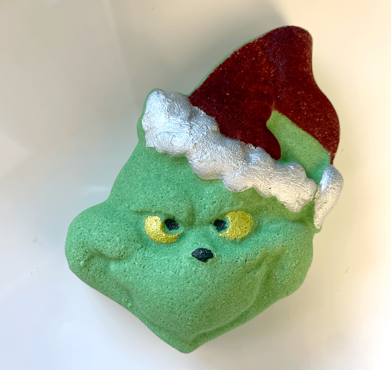 Green character with a red hat and white trim on a light background
