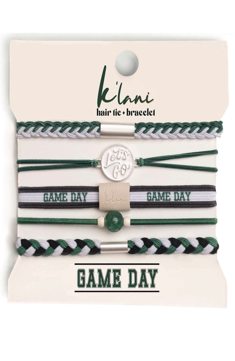 A set of Kiani hair tie and bracelet accessories on a cream-colored display card. The set includes multiple elastic bands in green, white, and black, featuring braided, striped, and solid patterns, along with a silver-toned round charm that reads 'Let's GO'.
