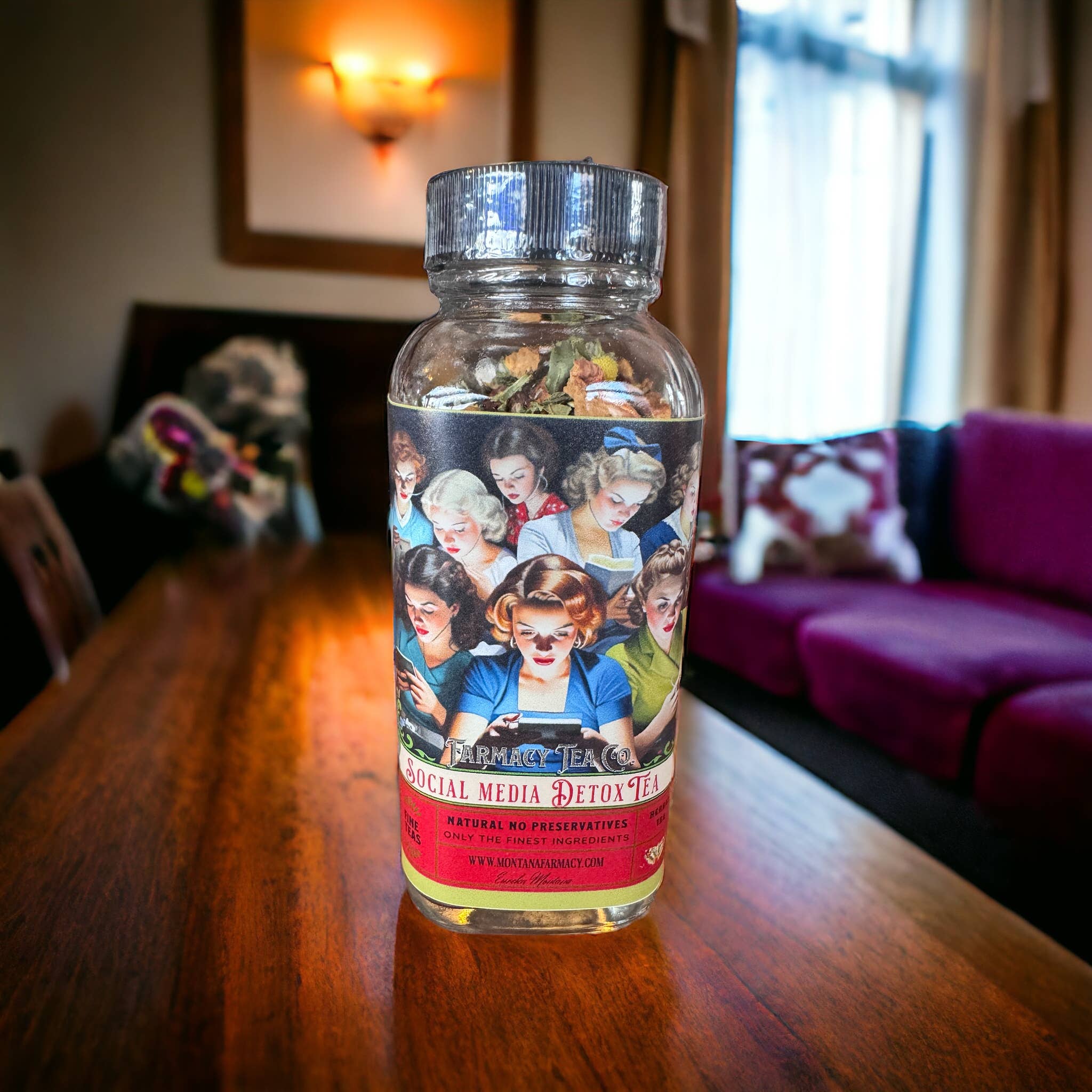 Bottle of 'Social Media Detox Tea' on a wooden table with a blurred indoor background