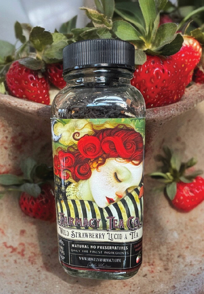 Bottle of 'Herbacy Tea Co.' wild strawberry licorice tea with strawberries in the background