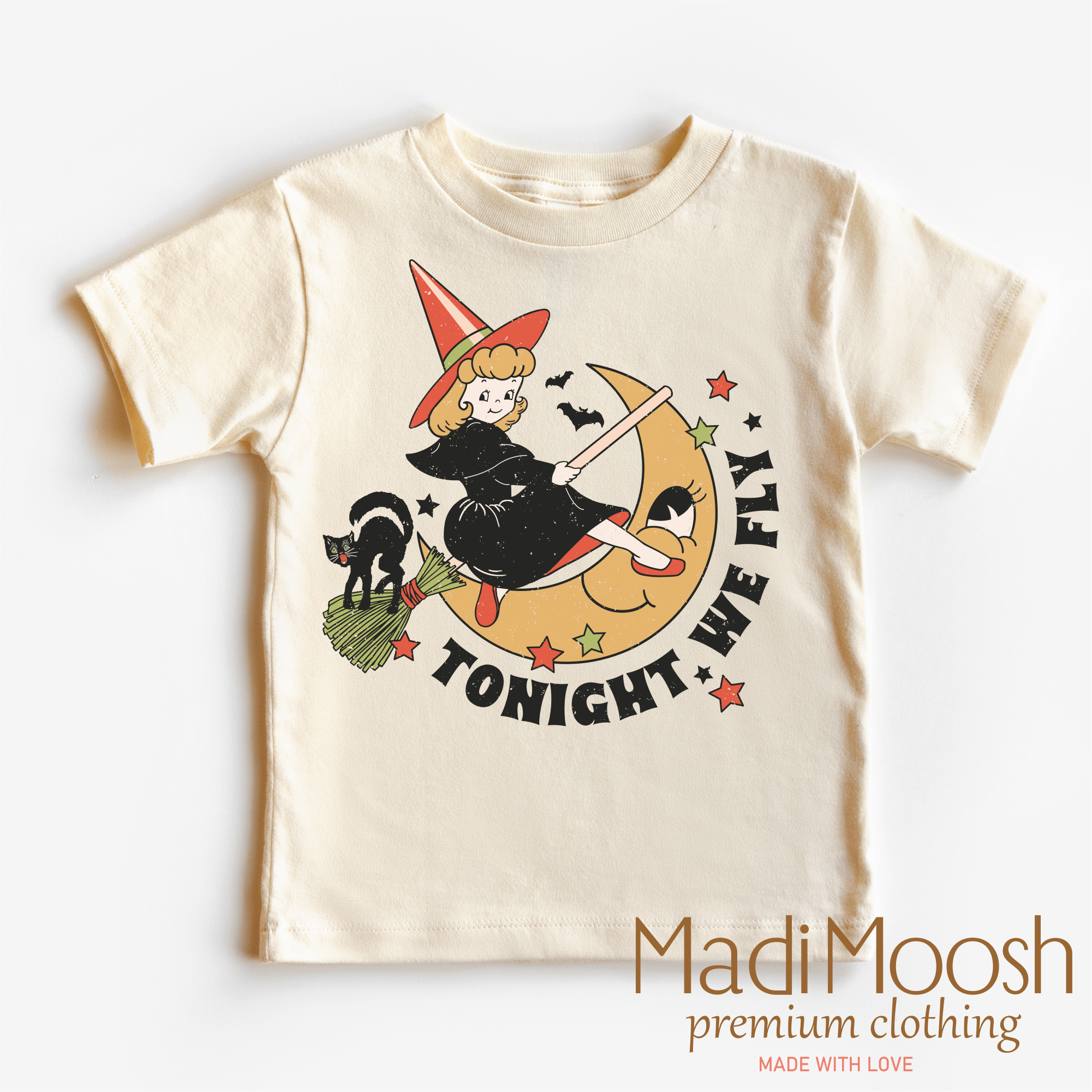 Children's t-shirt with Halloween-themed design featuring a witch on a broomstick, black cat, and text 'Tonight We Fly'. Brand 'Madi Moosh' is visible.