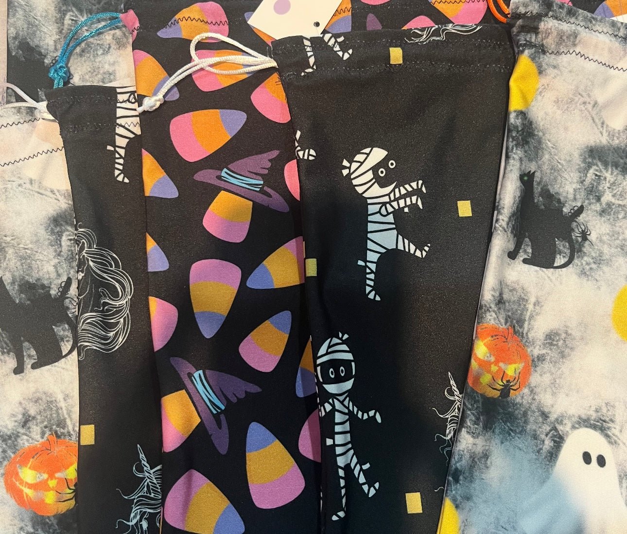 Black grip bags with Halloween-themed designs on a patterned background