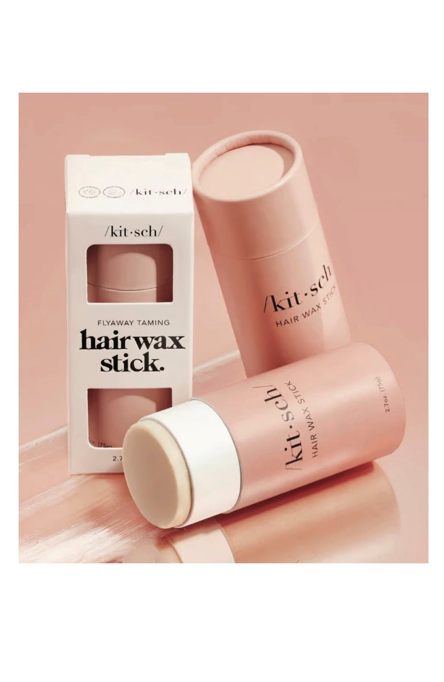Kit-sch Everyday Taming Hair Wax Stick set, featuring a white box, a pink cylindrical stick container, and a second pink container lying down, all on a soft pink background.