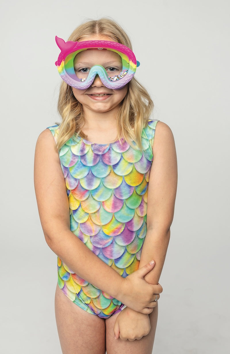 Child wearing a colorful swimsuit with a fish-themed goggles on a plain background