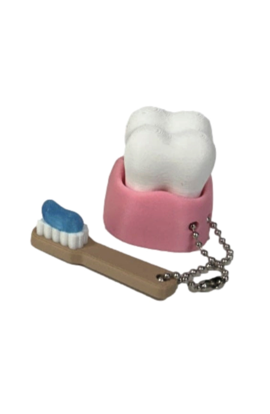 A small novelty toothbrush and tooth holder set on a plain white background. The toothbrush has a tan handle, white bristles, and blue toothpaste, while the tooth holder is pink with a white tooth inside and a silver ball chain attached.